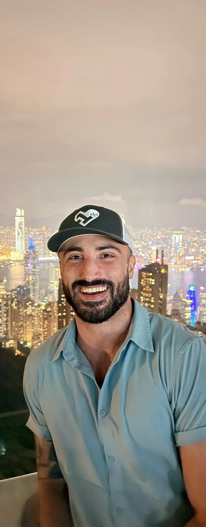 OPH trucker hat with the Hong Kong skyline lit up at night in the background