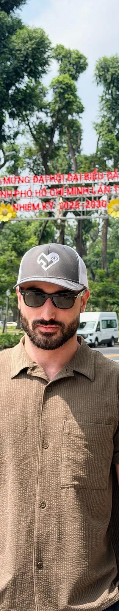 OPH trucker hat on a Saigon street with a red Vietnamese government banner overhead