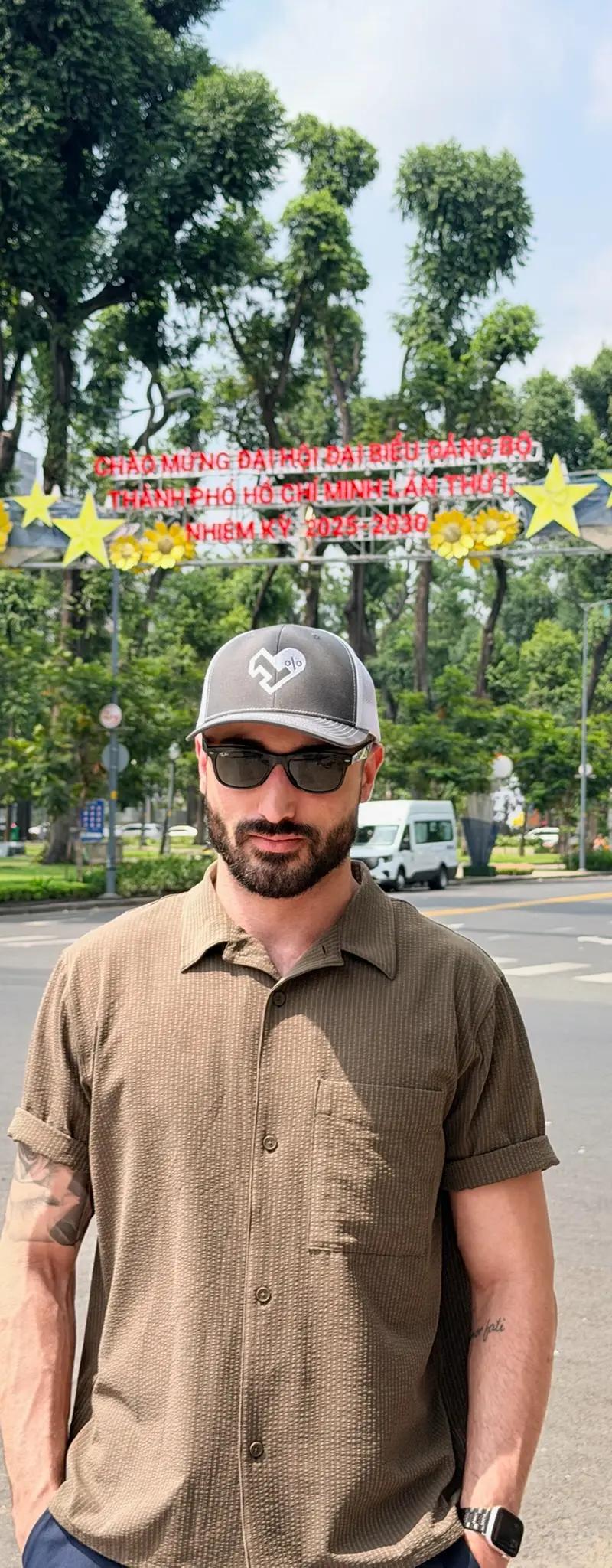 OPH trucker hat on a Saigon street with a red Vietnamese government banner overhead