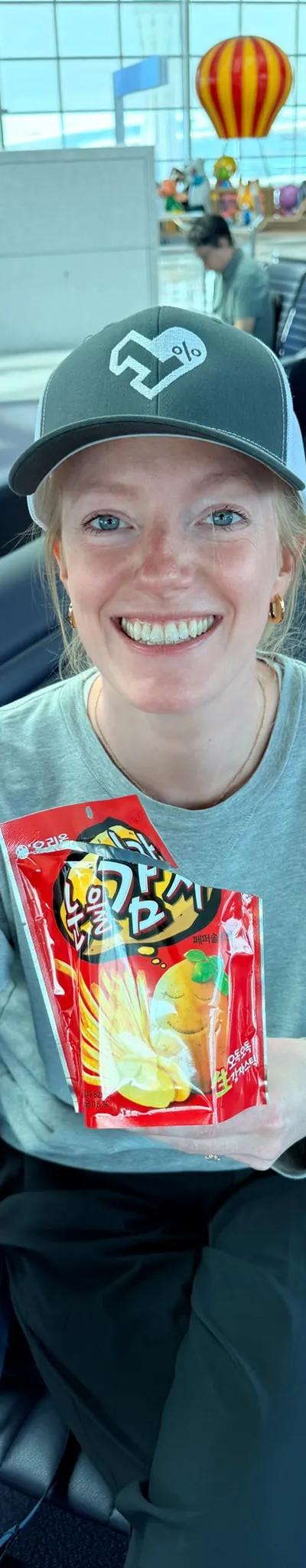 OPH trucker hat at Incheon Airport with a bag of Korean snacks