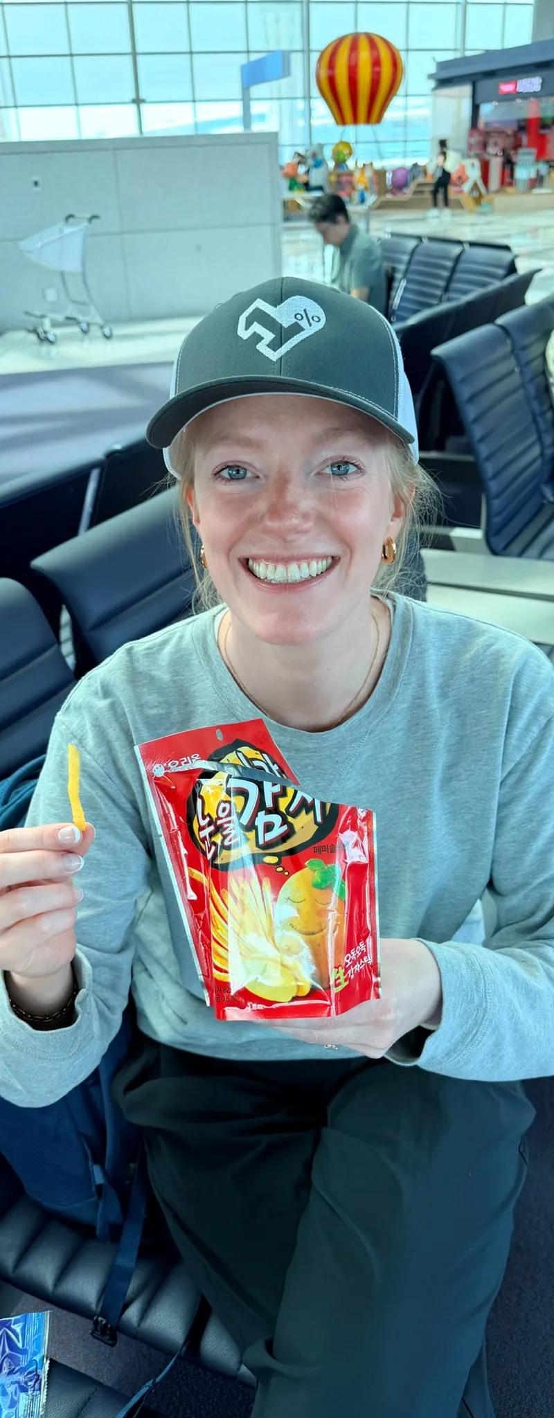 OPH trucker hat at Incheon Airport with a bag of Korean snacks